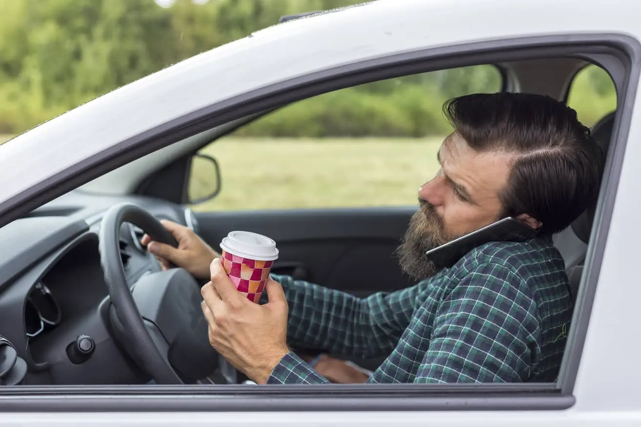 Young,Man,Speaking,On,Phone,And,Drinking,Coffee,While,Driving Bicycle hit by a car